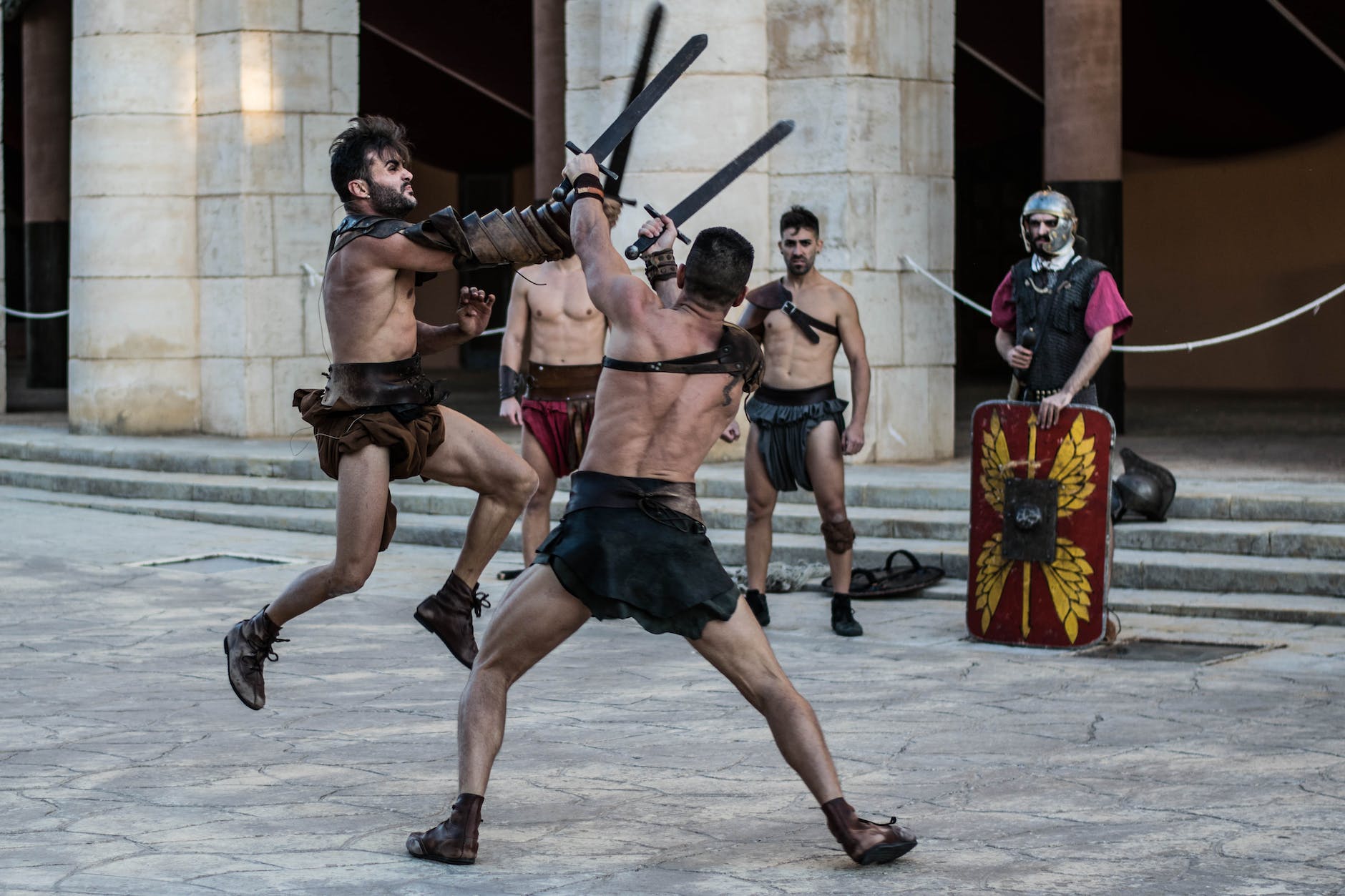 shirtless men fighting with sword