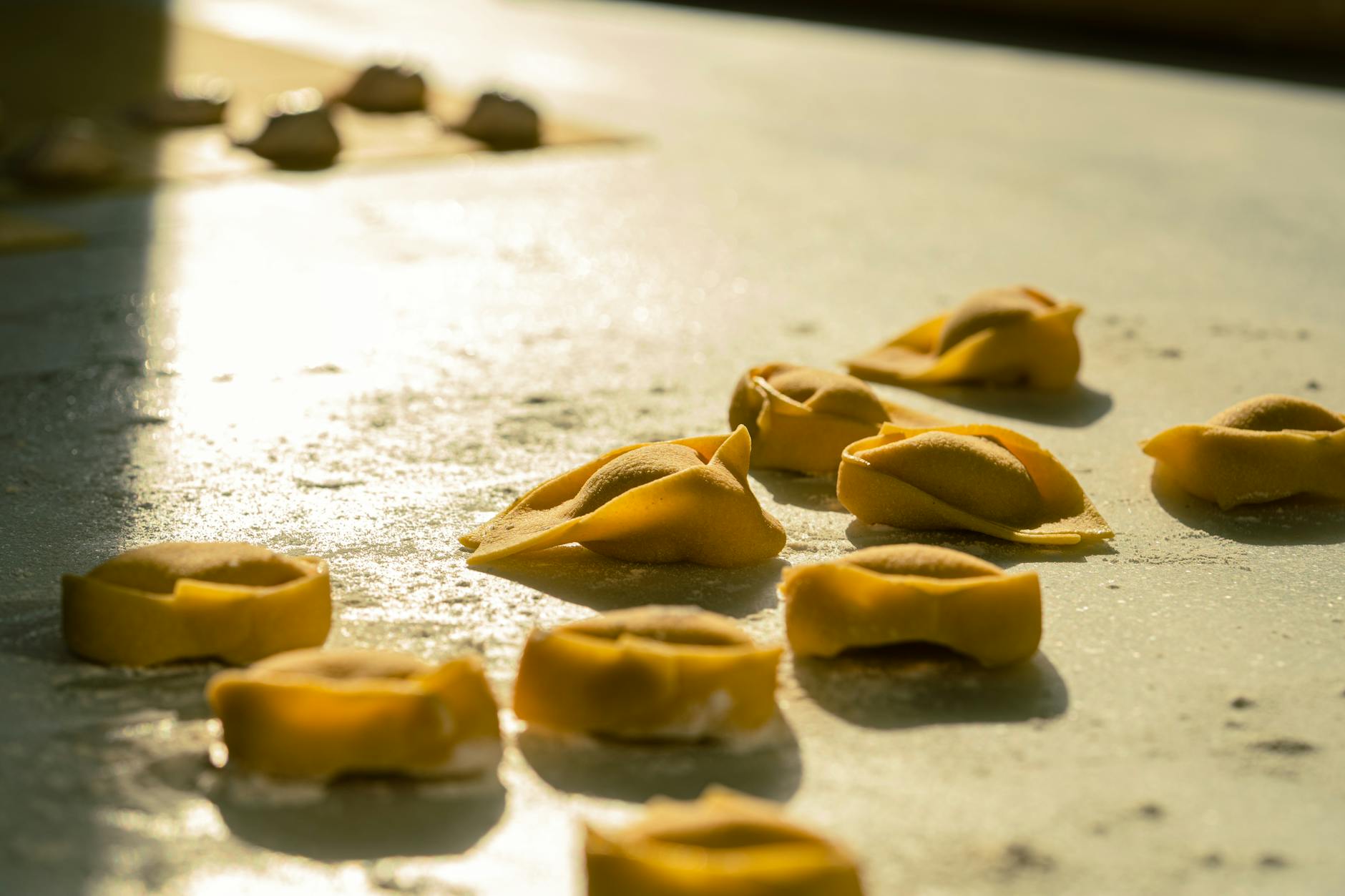 tortellini appena fatti sulla superficie della cucina illuminata dal sole