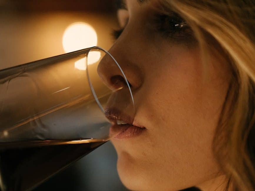 donna che beve da un bicchiere trasparente