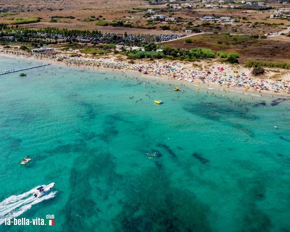 Vista aerea della spiaggia di Pescoluse, alias Maldive del Salento, nel sud dell'Italia - Spiaggia pugliese con acque turchesi in estate - Idilliaca destinazione di vacanza lungo lo Ionio ... Mostra di più