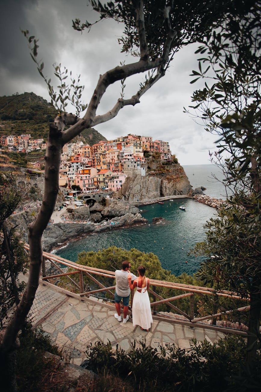 a couple looking at the houses on the cliff in cinque terre italy