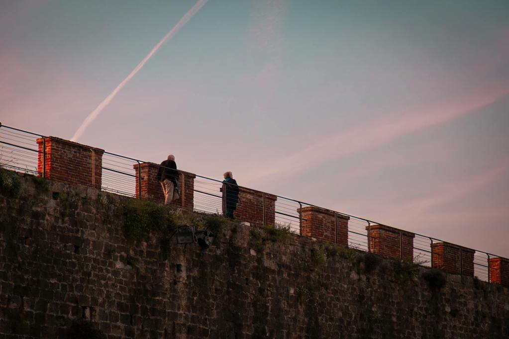 Les gens marchent sur le mur historique au coucher du soleil